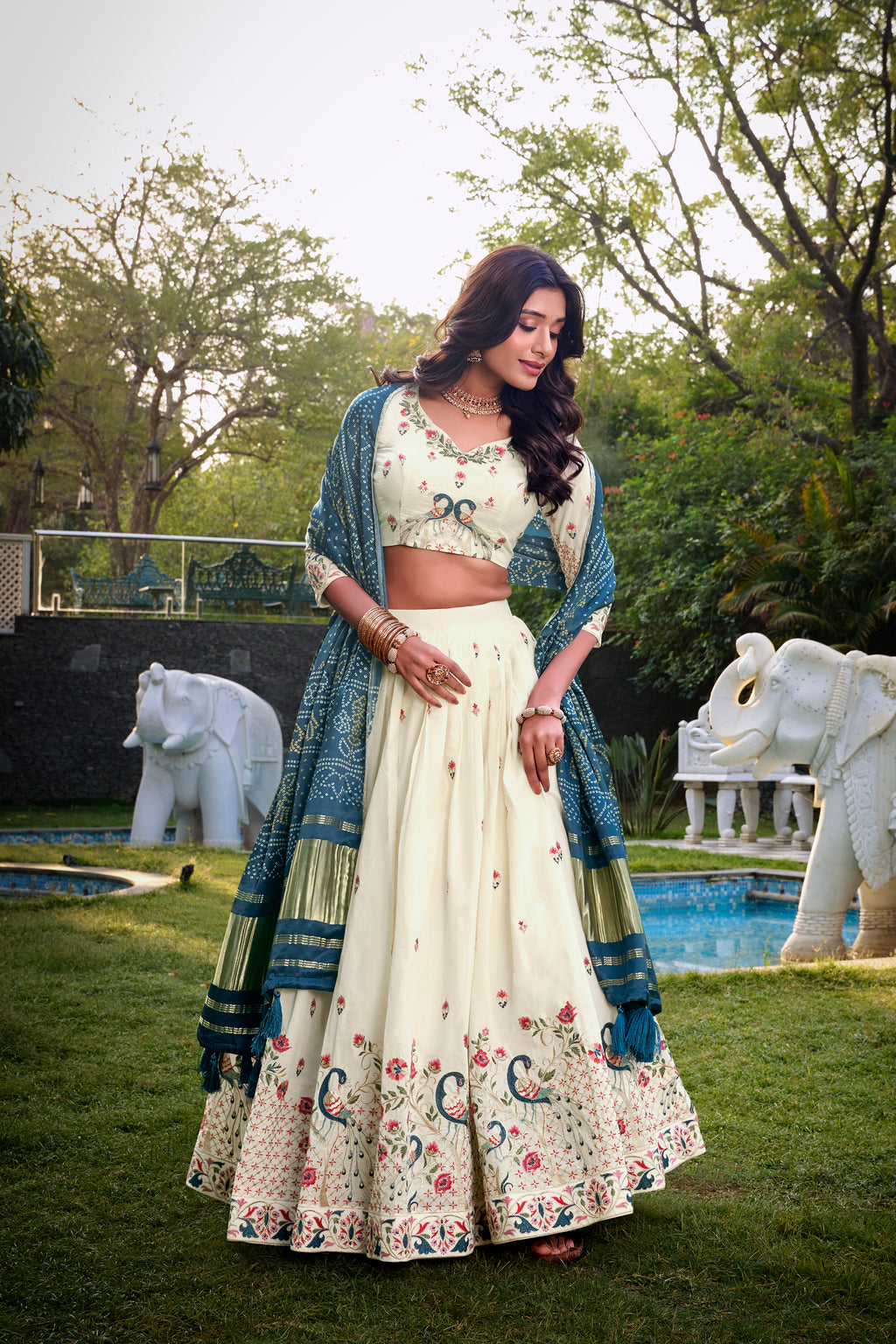 A vision of grace in an ivory lehenga adorned with peacock motifs.