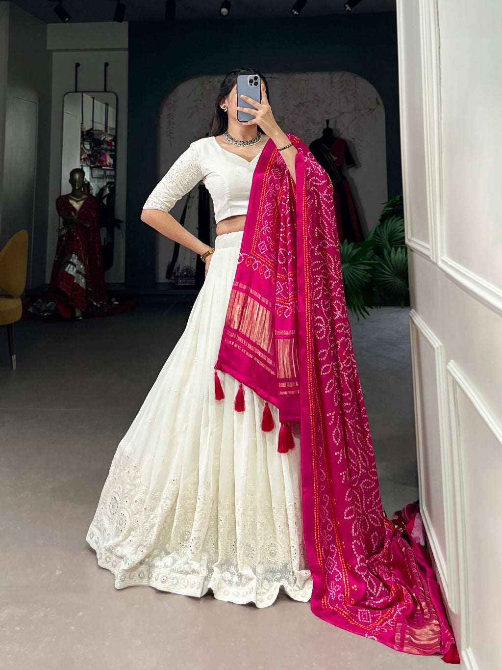 A chic white lehenga brought to life by a stunning rust and blue dupatta.