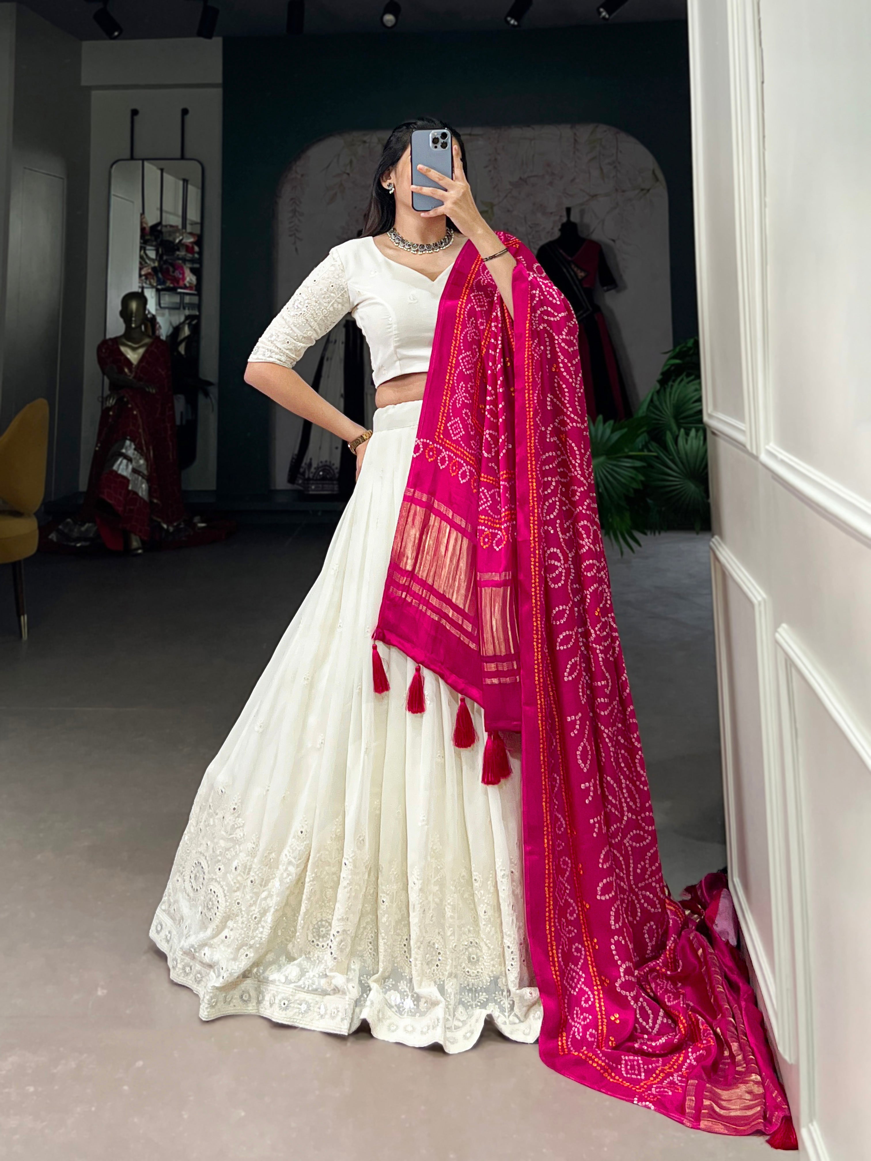 A chic white lehenga brought to life by a stunning rust and blue dupatta.