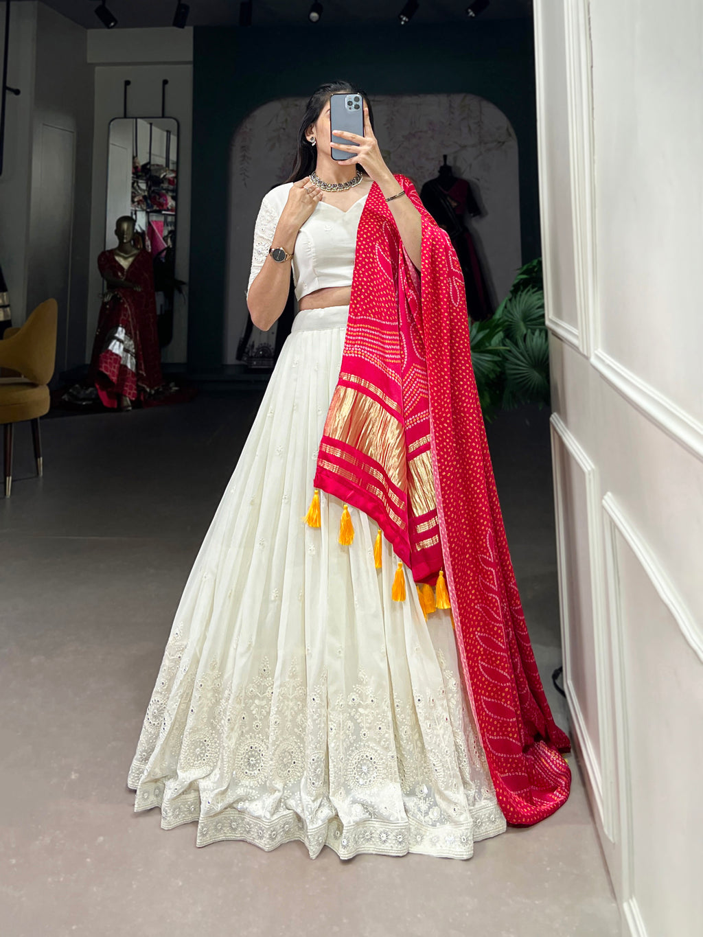 A chic white lehenga brought to life by a stunning rust and blue dupatta.