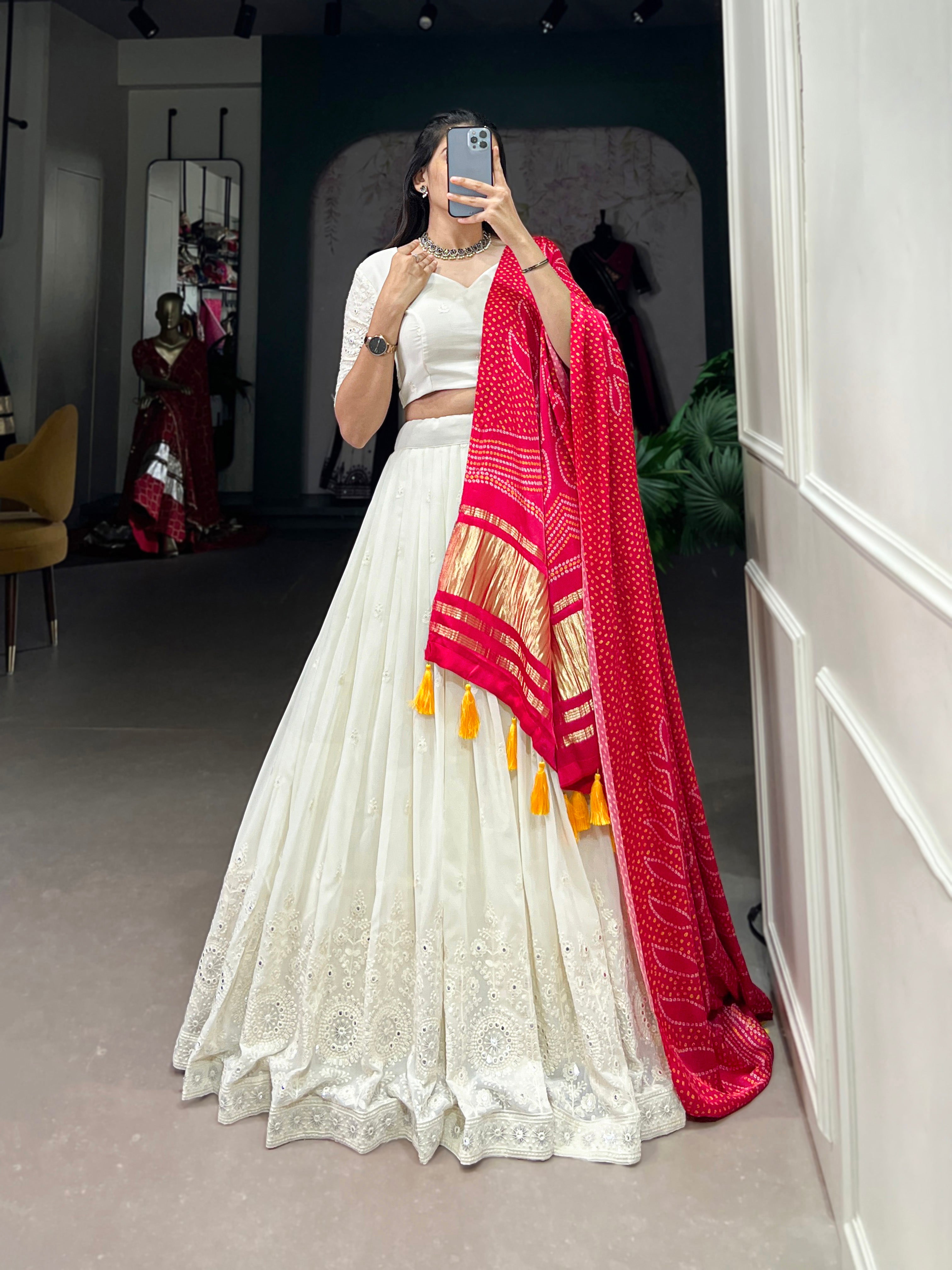 A chic white lehenga brought to life by a stunning rust and blue dupatta.