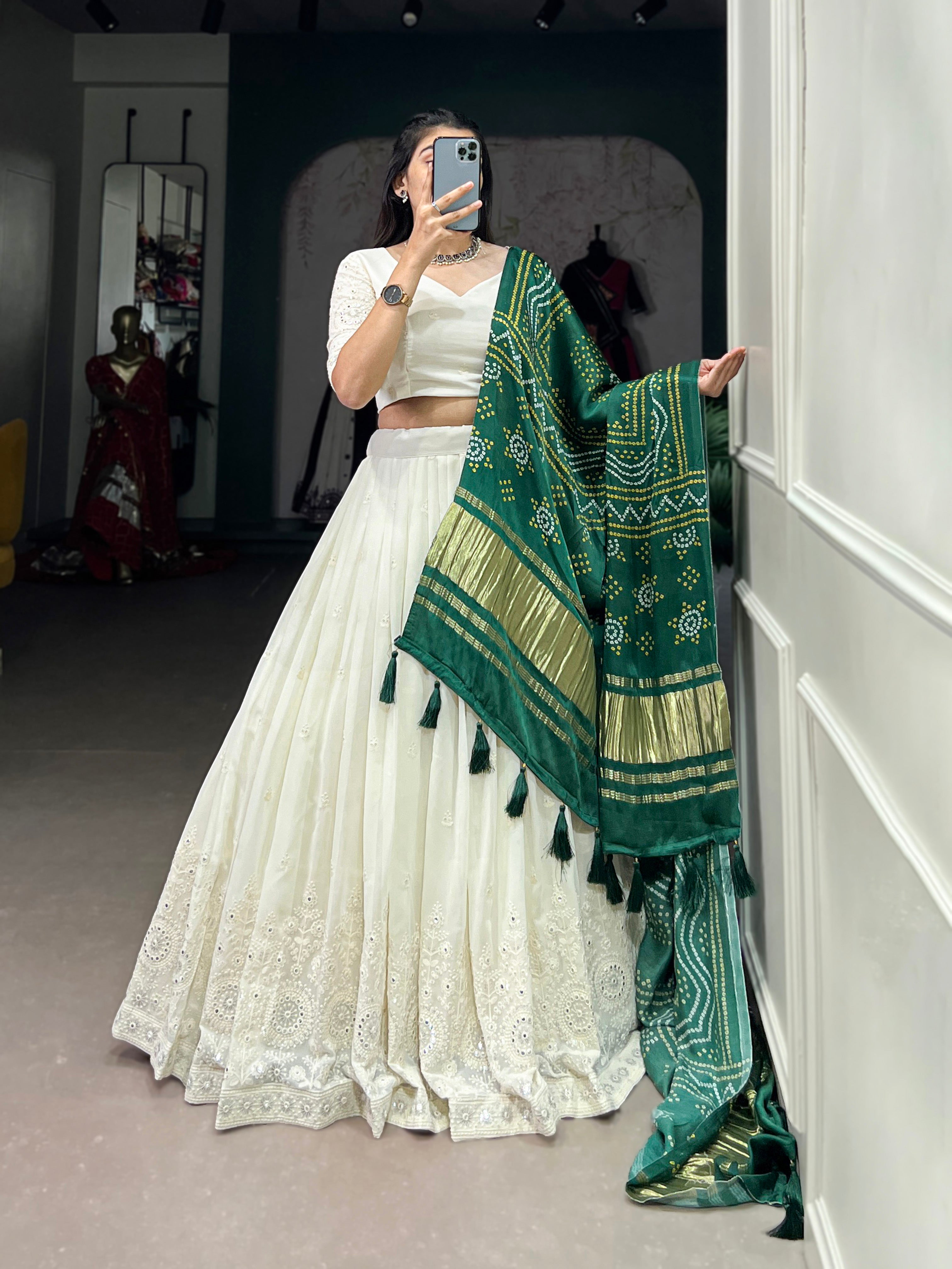 A chic white lehenga brought to life by a stunning rust and blue dupatta.