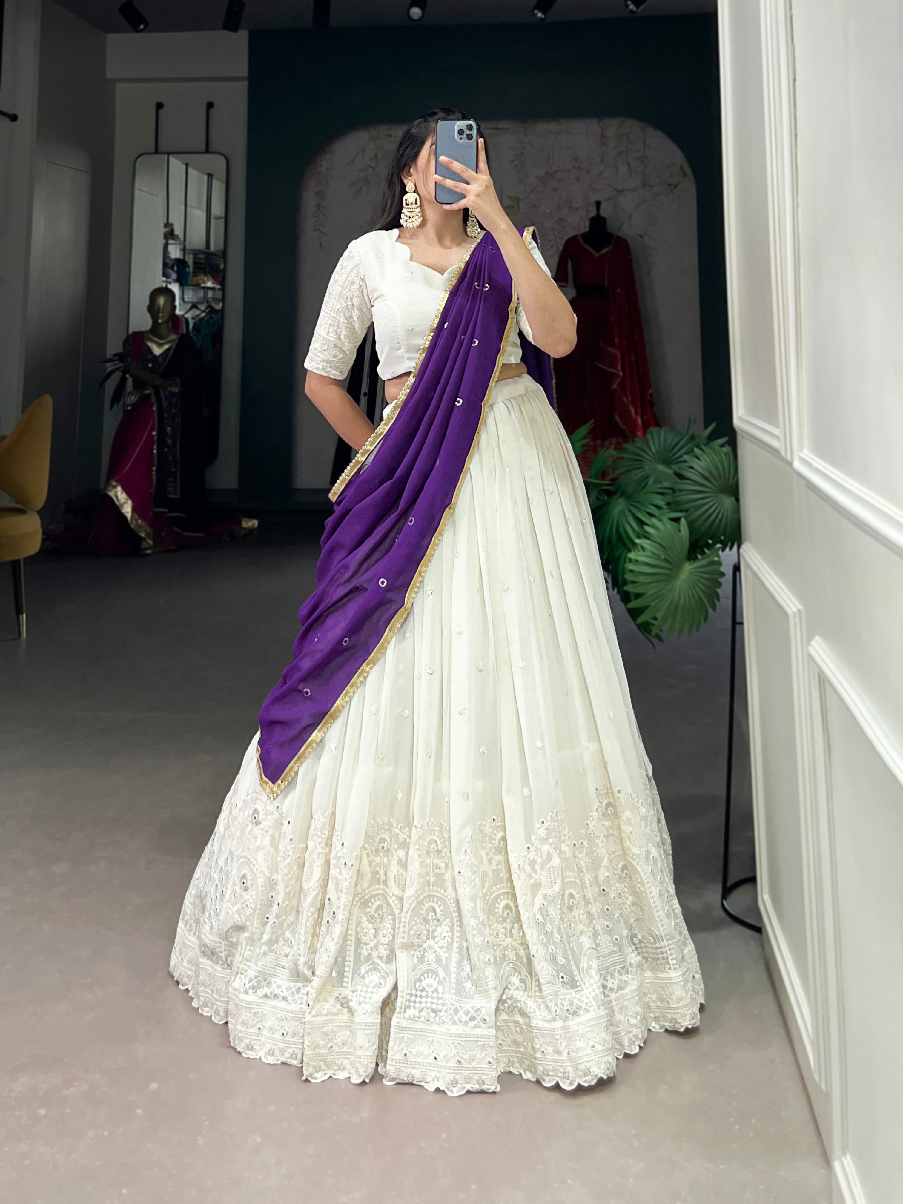 An elegant white lehenga made regal with a vibrant purple dupatta.