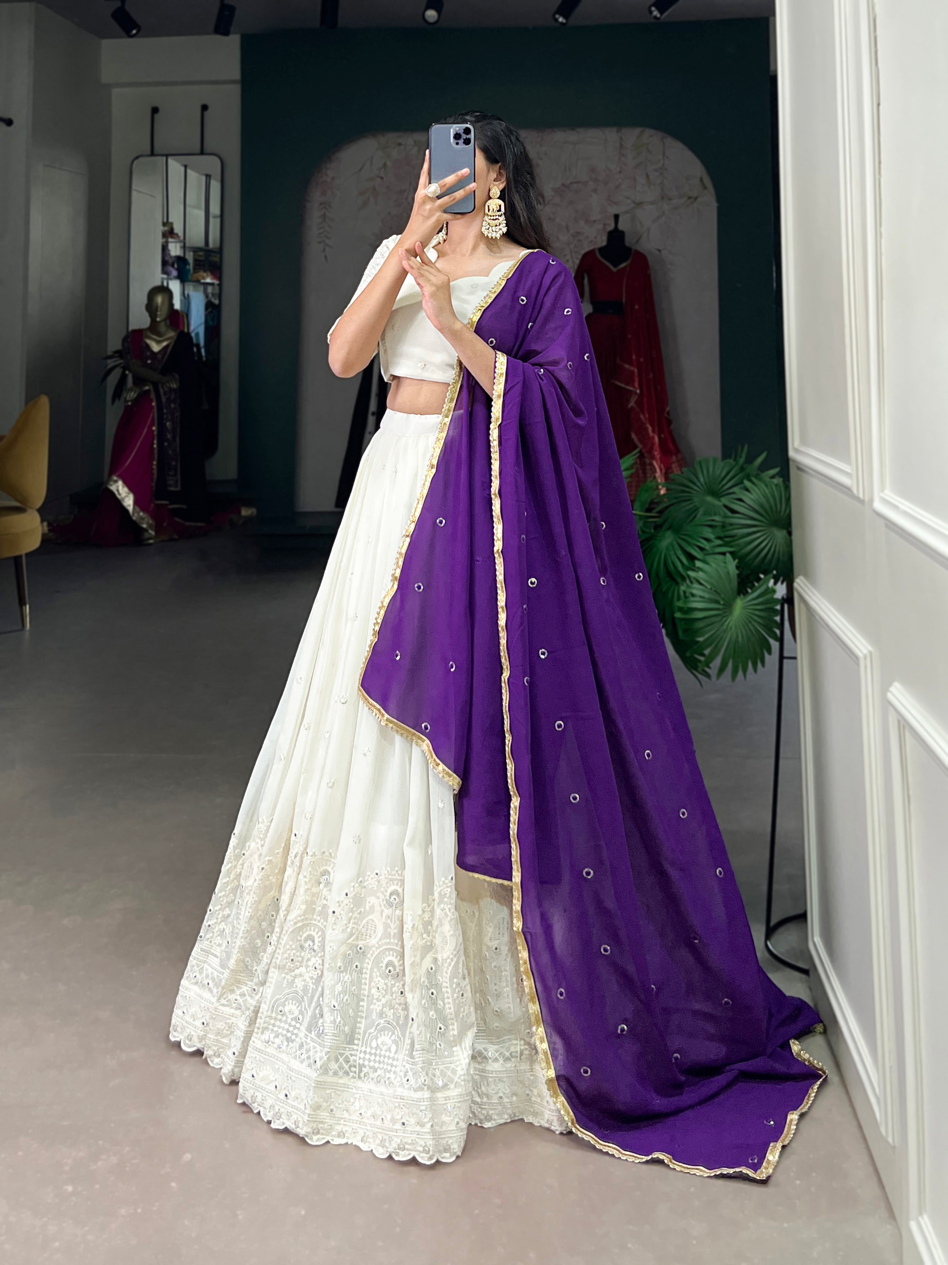 An elegant white lehenga made regal with a vibrant purple dupatta.