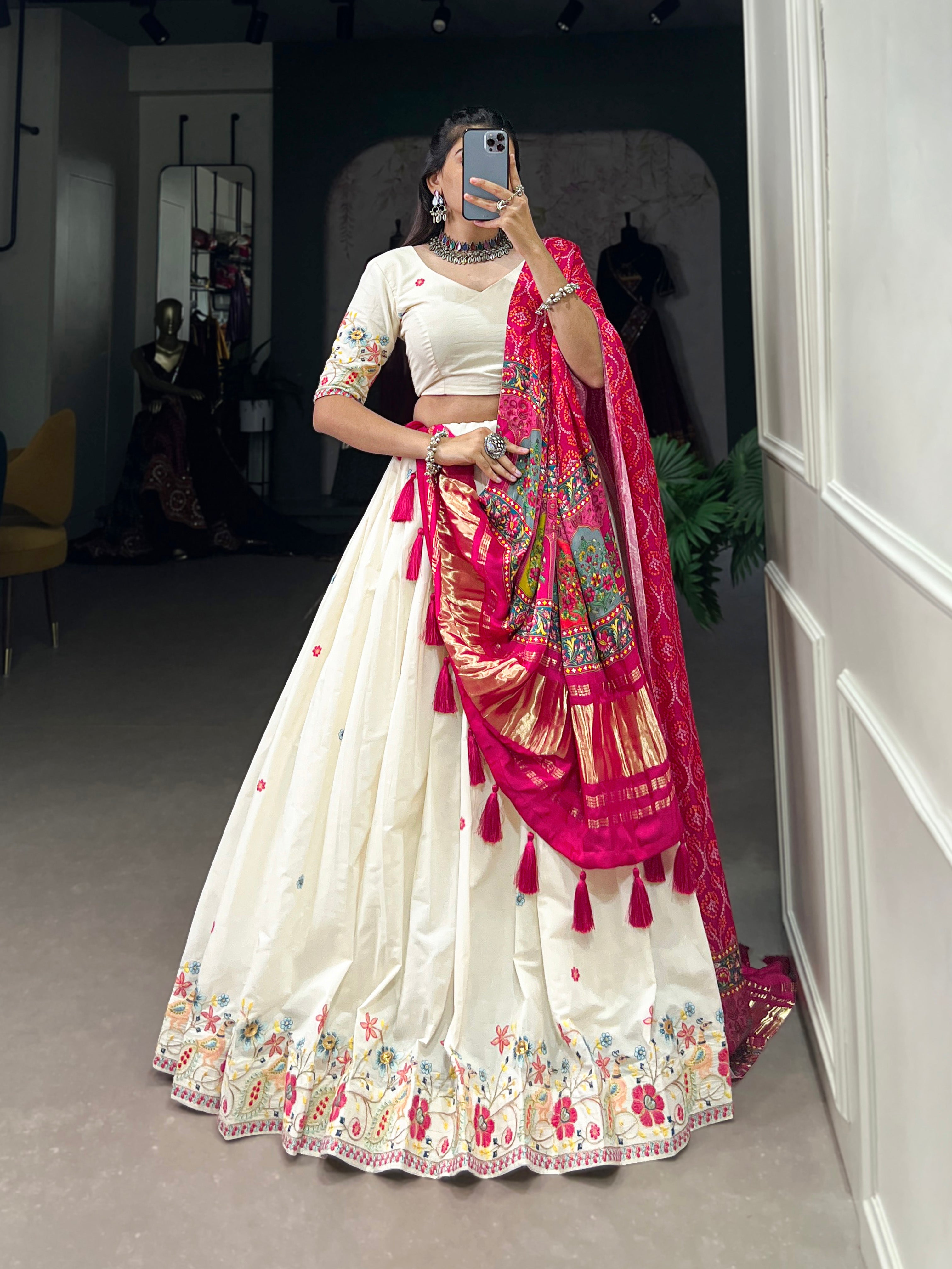 An elegant ivory lehenga made vibrant by a stunning multi-hued pink dupatta