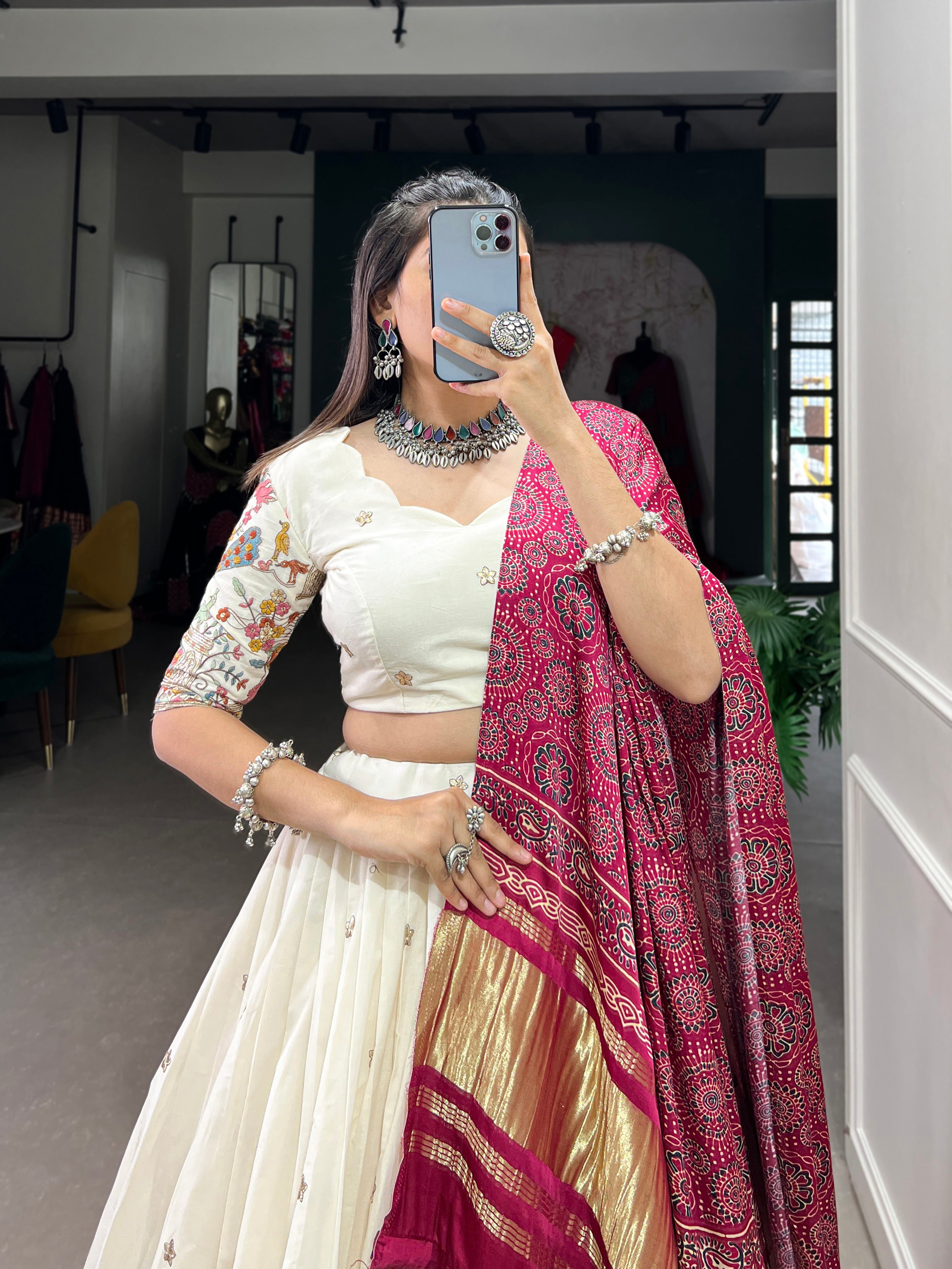 An elegant ivory lehenga made vibrant by a stunning multi-hued pink dupatta