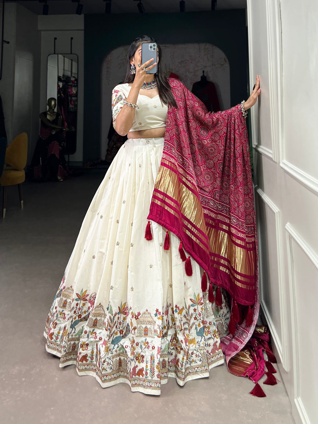 An elegant ivory lehenga made vibrant by a stunning multi-hued pink dupatta