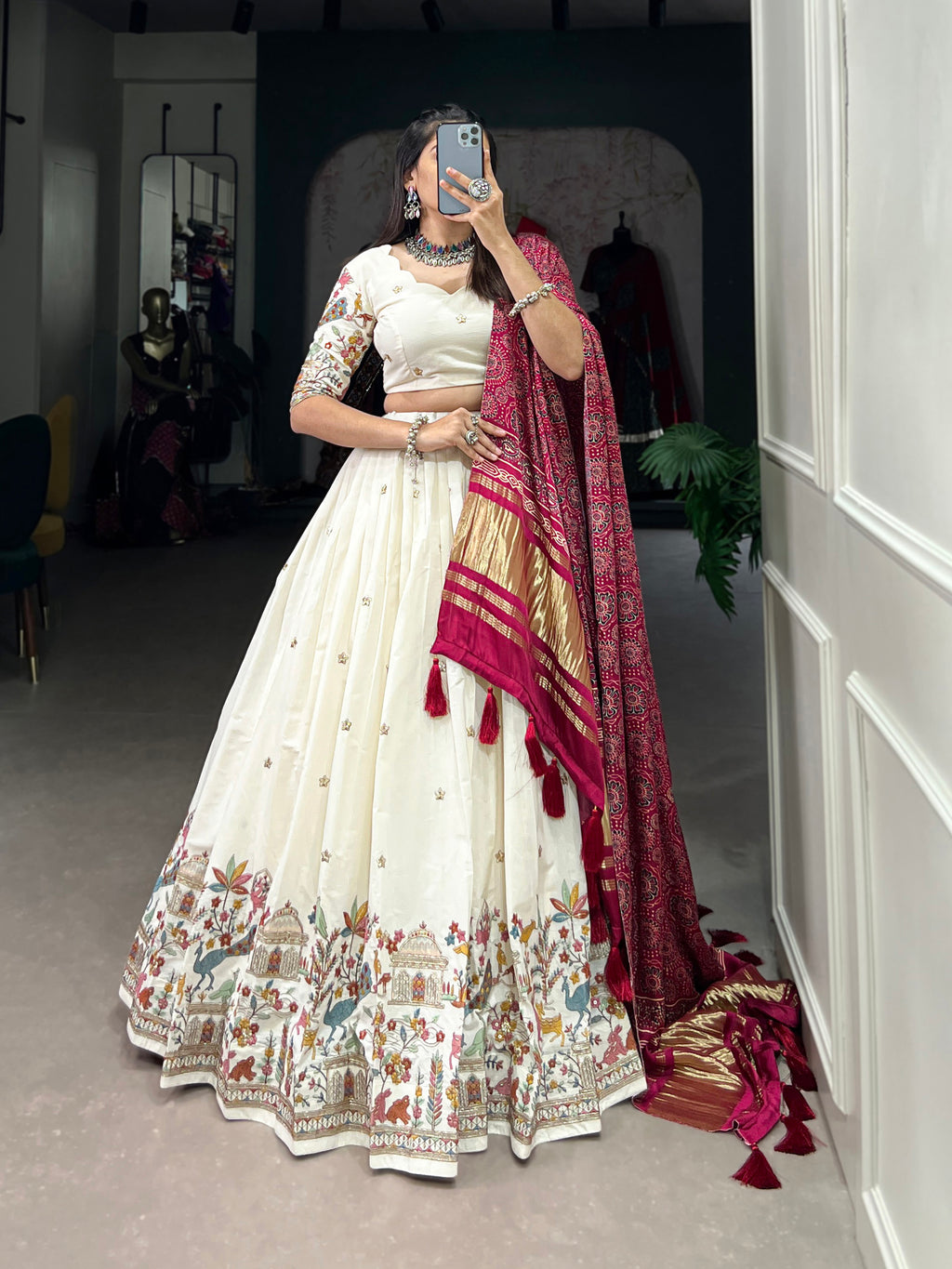 An elegant ivory lehenga made vibrant by a stunning multi-hued pink dupatta