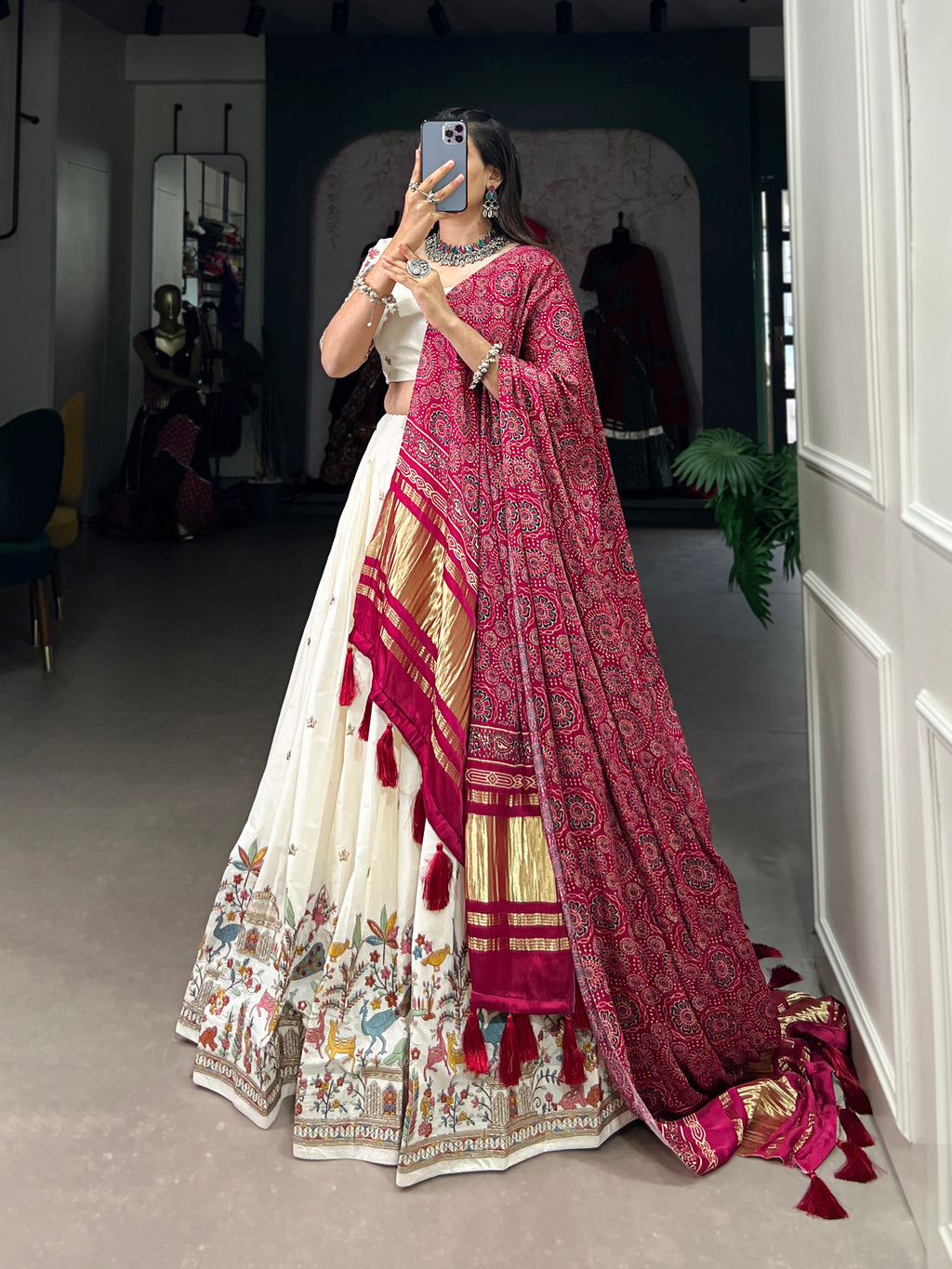 An elegant ivory lehenga made vibrant by a stunning multi-hued pink dupatta