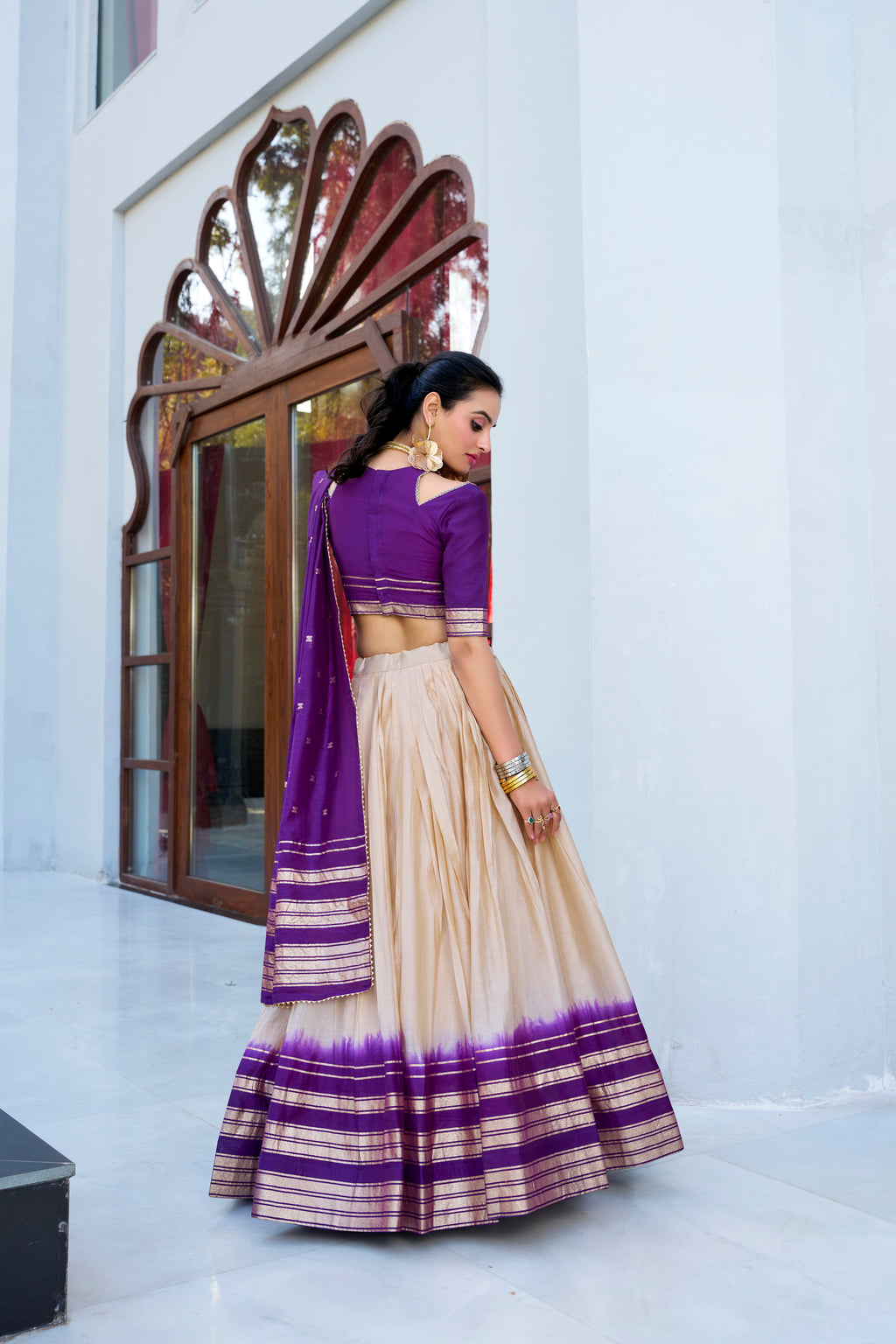 Regal sophistication in a stunning cream and purple lehenga.