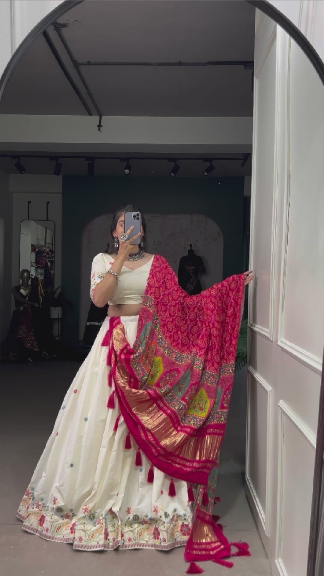 An elegant ivory lehenga made vibrant by a stunning multi-hued pink dupatta